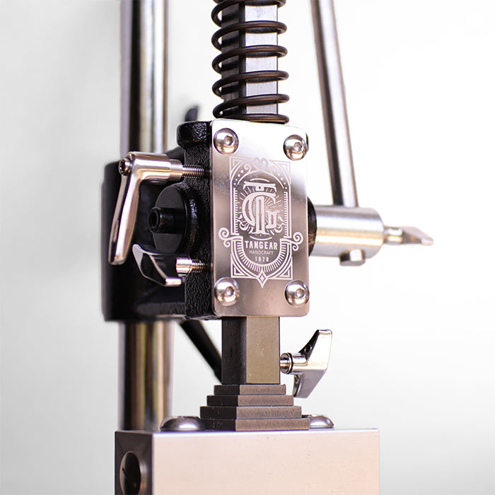 Close-up of long steel pressure lever with ergonomic grip on manual leather press tool