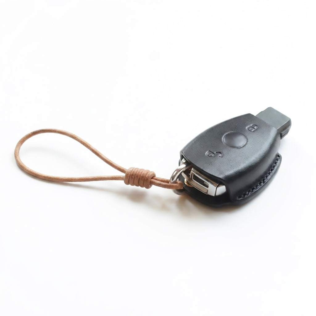 Detail shot of expert artisan stitching on a TanGear handcrafted leather key cover for Mercedes